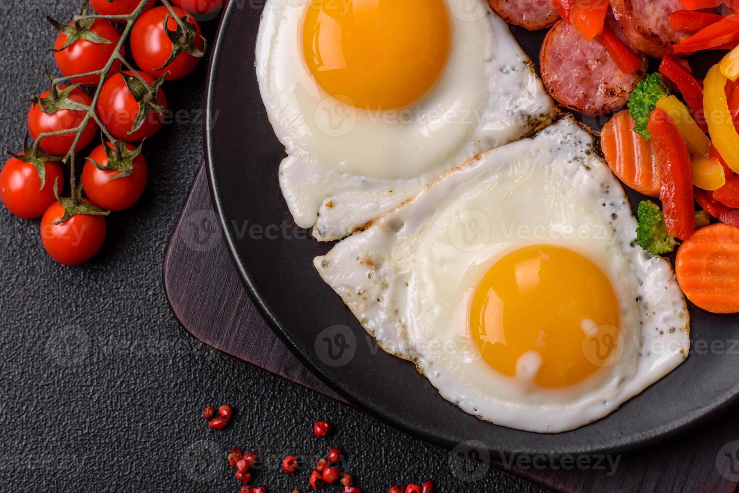 Delicious nutritious breakfast with fried eggs, sausage, steamed vegetables photo