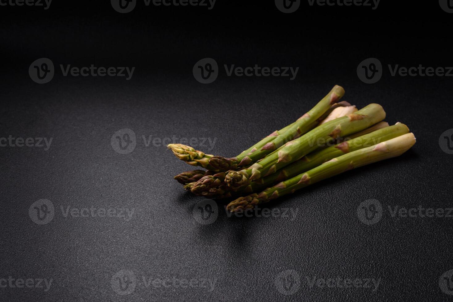 Sprigs of raw green asparagus as an ingredient for preparing a healthy breakfast photo