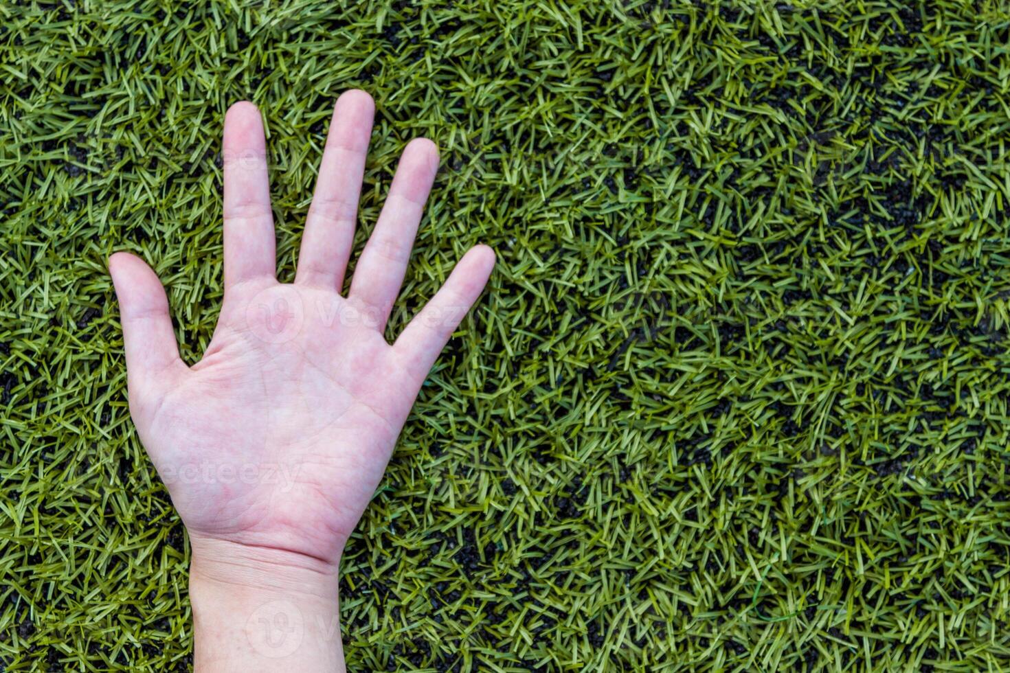 girl hand on soccer field grass photo