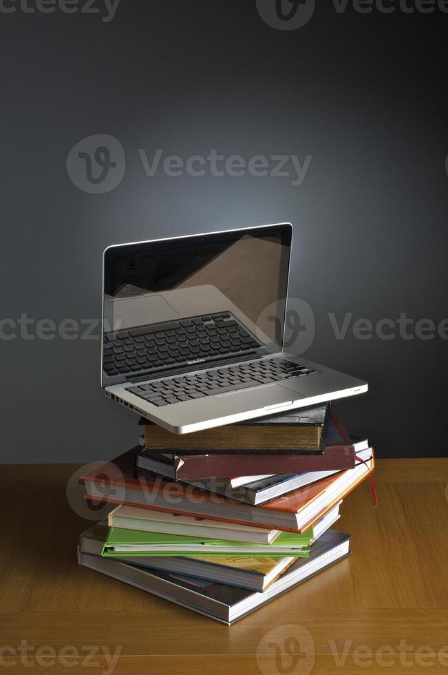 Stack of book and laptop photo