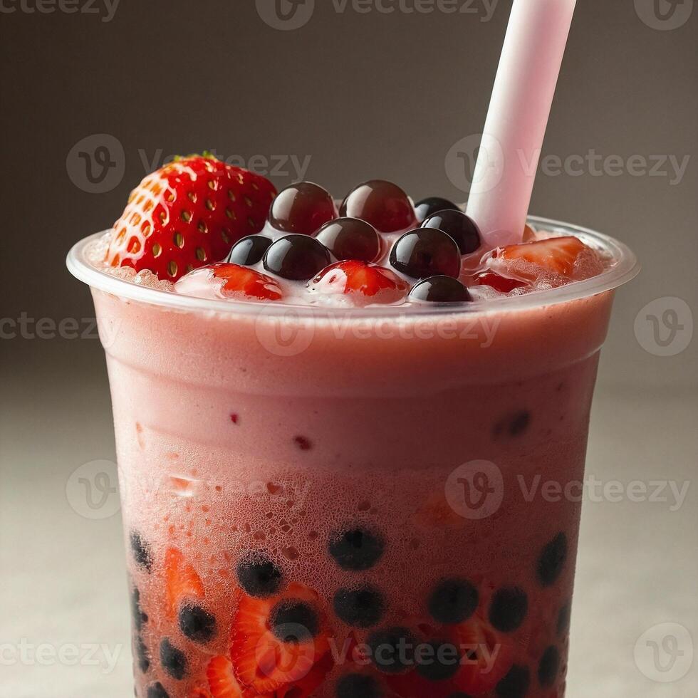 Close up view of refreshing strawberry bubble tea with tapioca pearls visible at the bottom in the plastic cup with straw photo