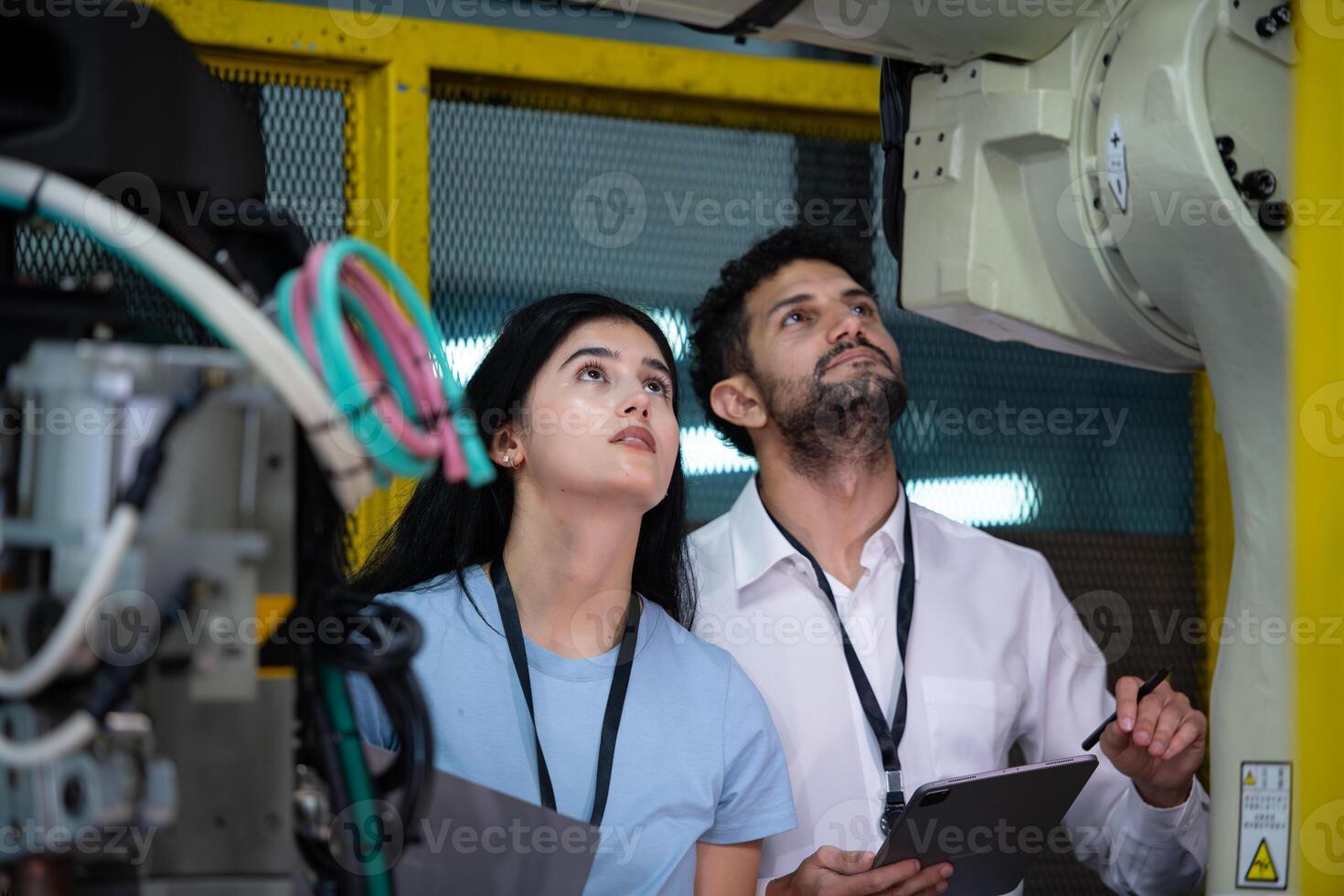Technicians are introducing industrial hand robots to businessperson of factory industry who will use them in large-scale complex manufacturing operations. photo