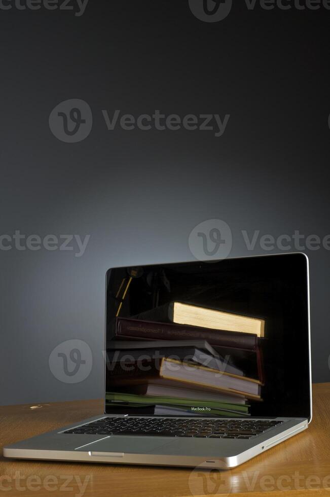 Stack of book and laptop photo