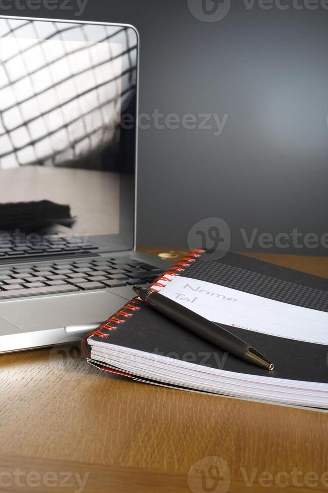 Phone, laptop and empty notebook on the desk photo