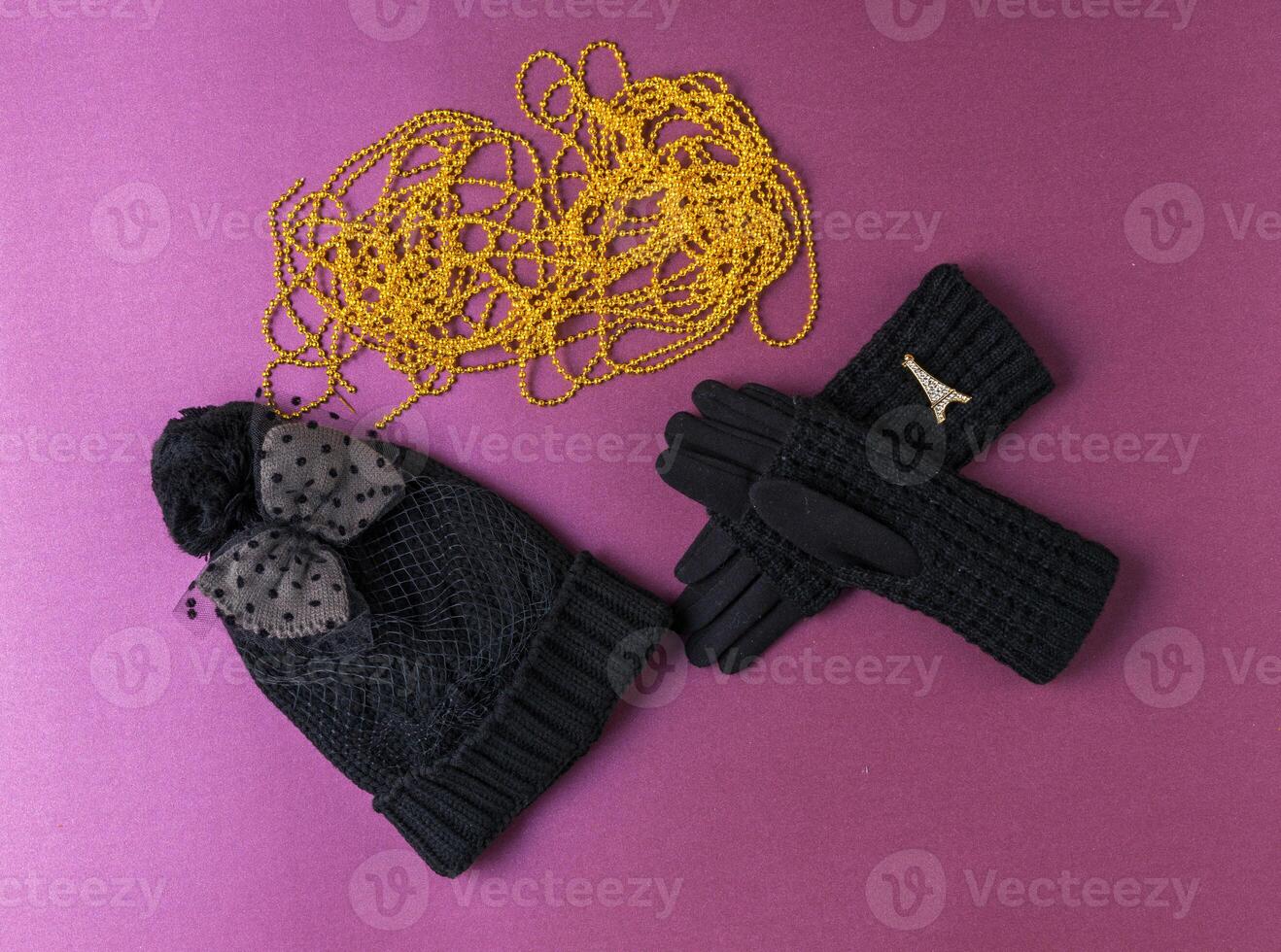 Set of winter cap, scarf and gloves on colored background photo