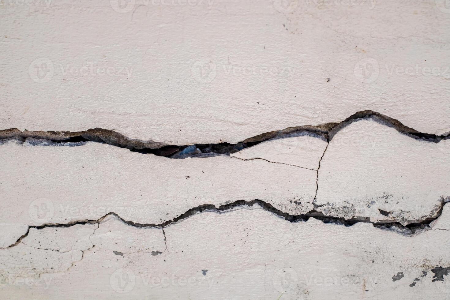 Cracked concrete wall broken wall at the outside cement corner that effected with earthquake and collapsed ground photo