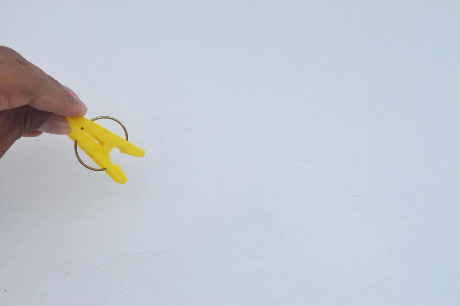 A person holding a yellow clothespin forming the letter A photo