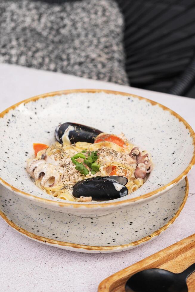Pasta with seafood in delicate cream sauce angle view. photo