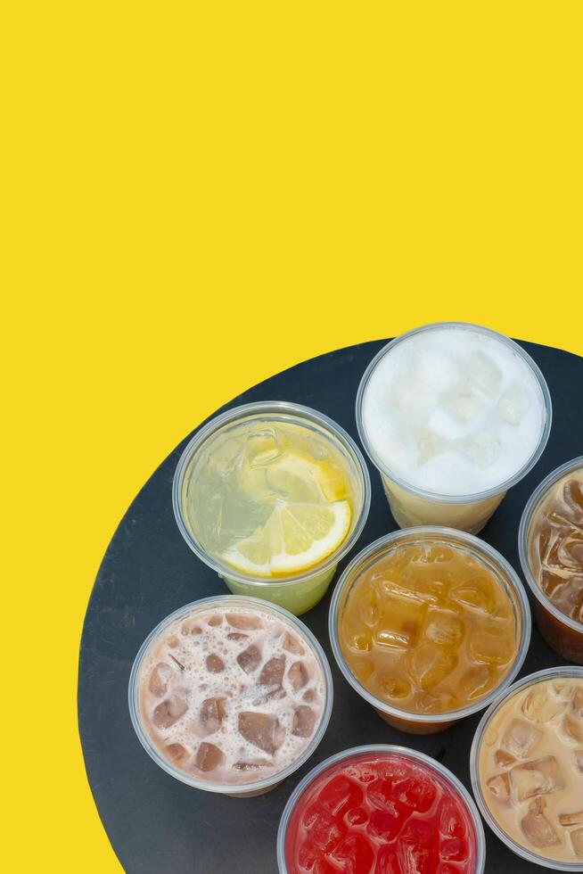Takeaway glasses of summer drinks with ice. Lemonades and coctails on the table photo