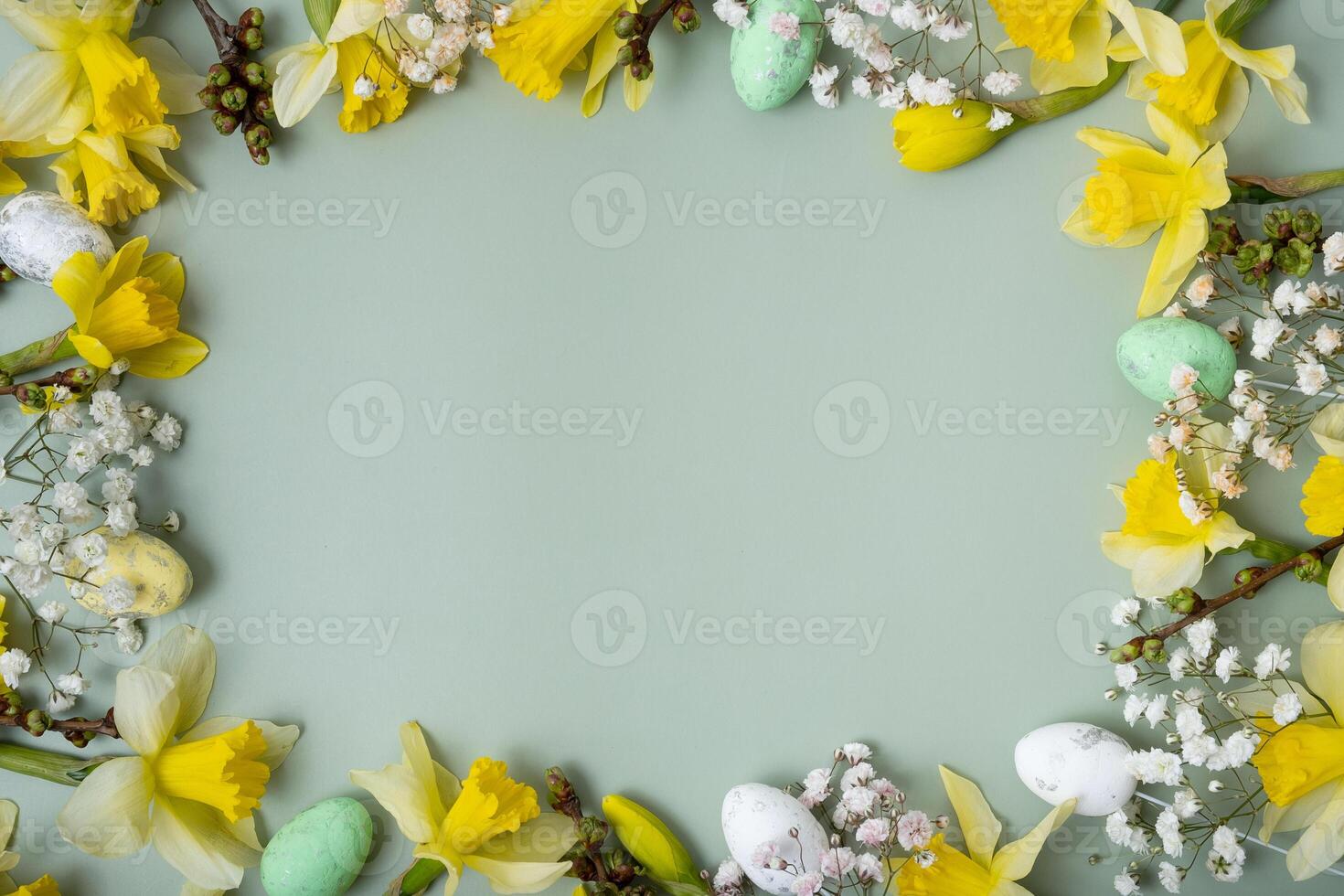 Spring flowers ans easter eggs border on green background with copy space. Easter greeting card template photo
