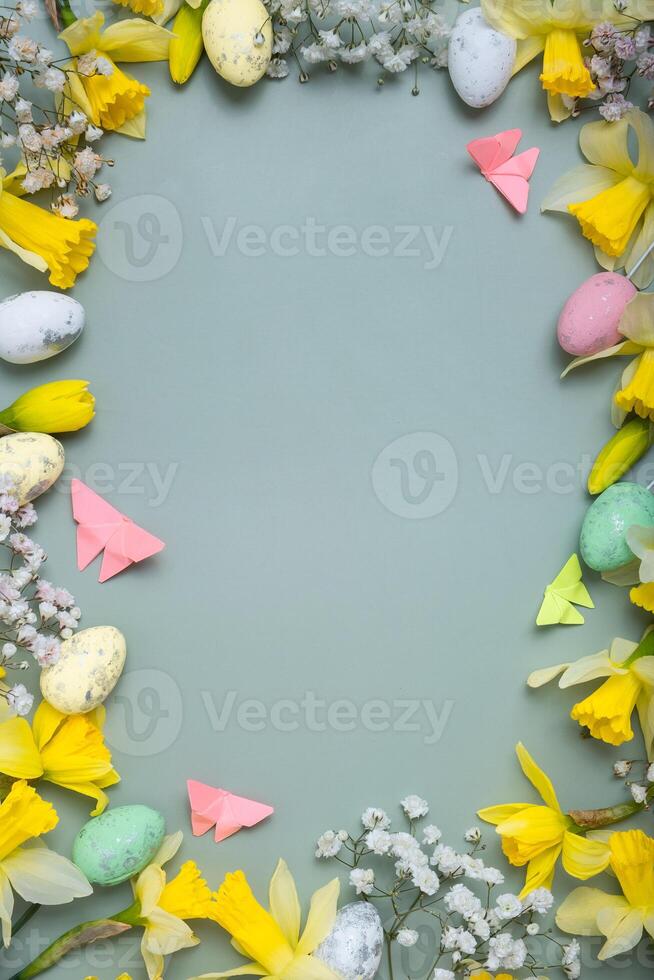 Spring flowers ans easter eggs border on green background with copy space. Easter greeting card template photo