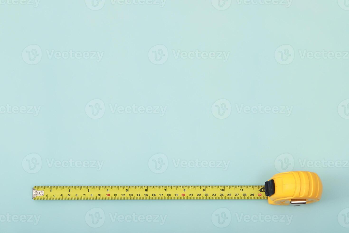 The yellow measuring tape for the mason is placed on a blue background. Soft focus. photo