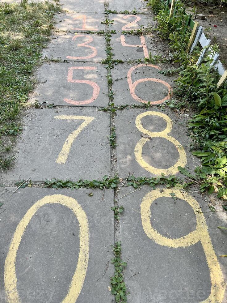 Route numbers. Child writing numbers in chalk. photo