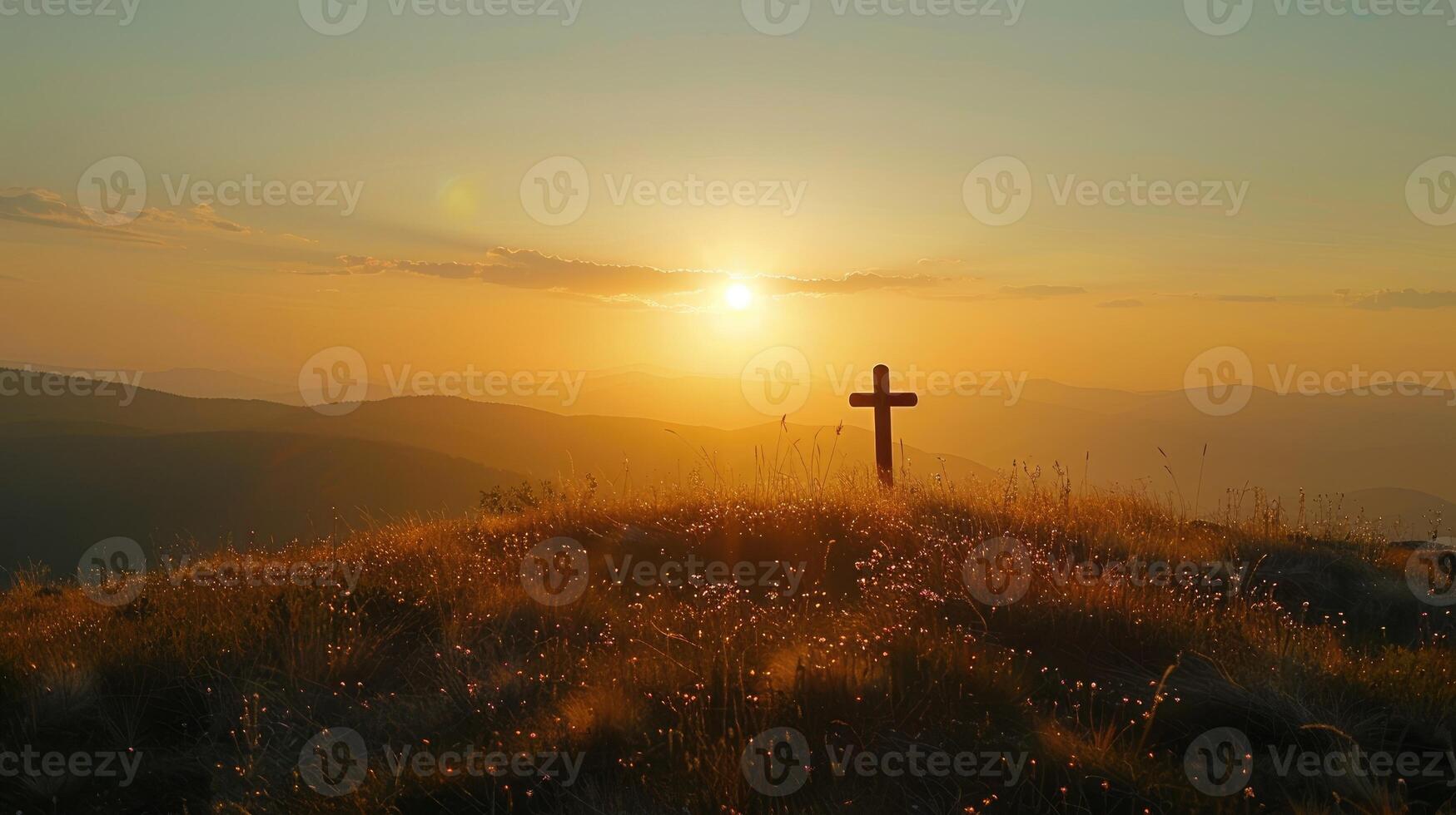 Silhouette of a cross on a hill in a mountain landscape at sunset. photo
