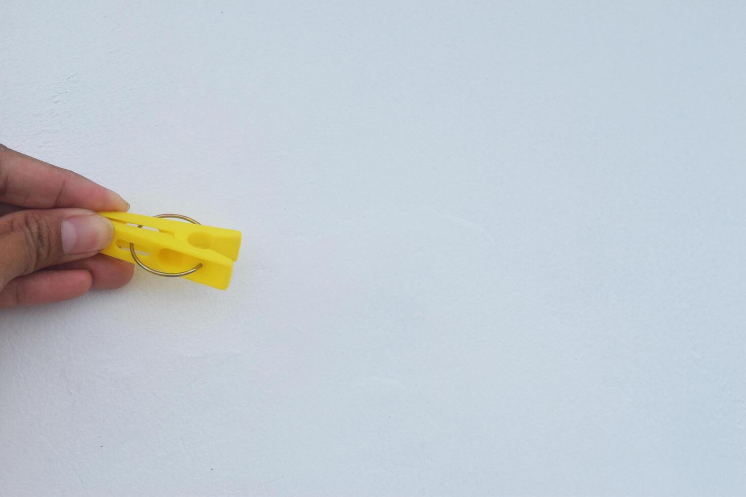 A person holding a yellow clothespin photo