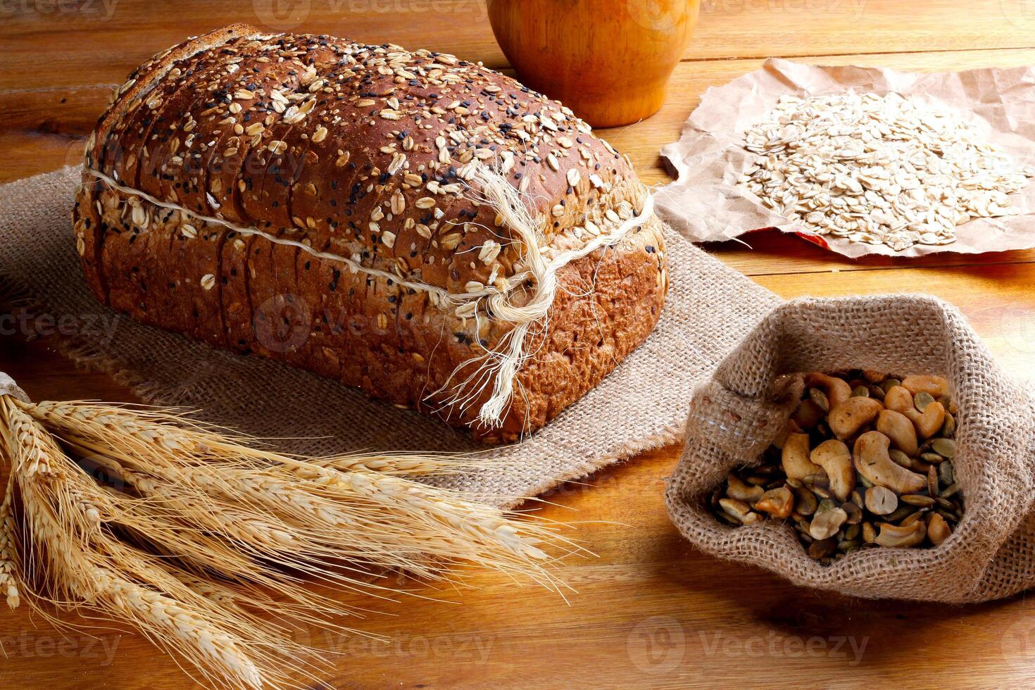 whole wheat bread with grains and seeds sliced on wooden table photo