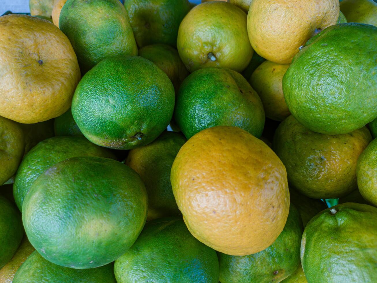 Pile of fresh tangerine fruit on market shelf photo