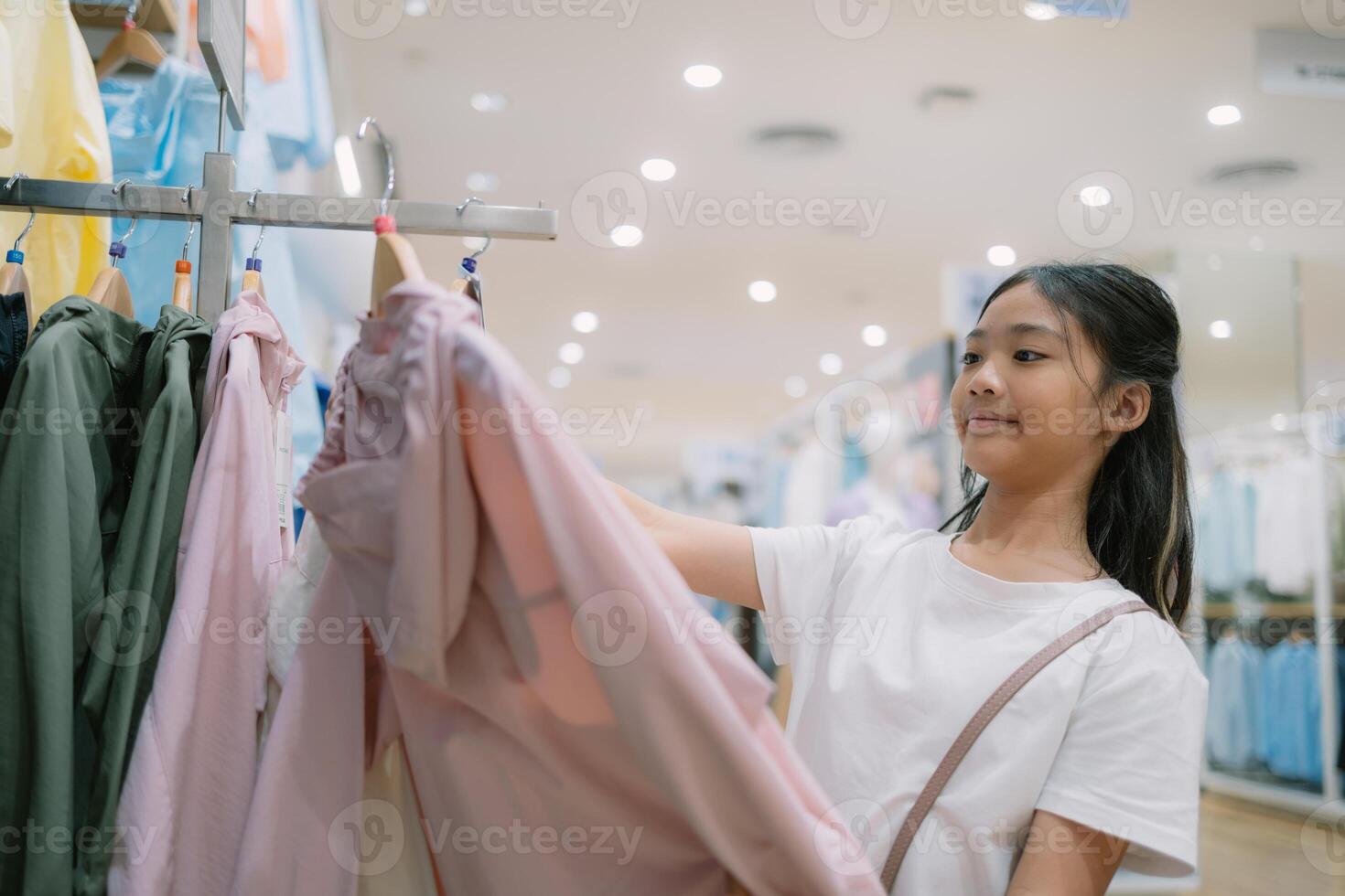 A young girl is shopping for clothes in a store photo