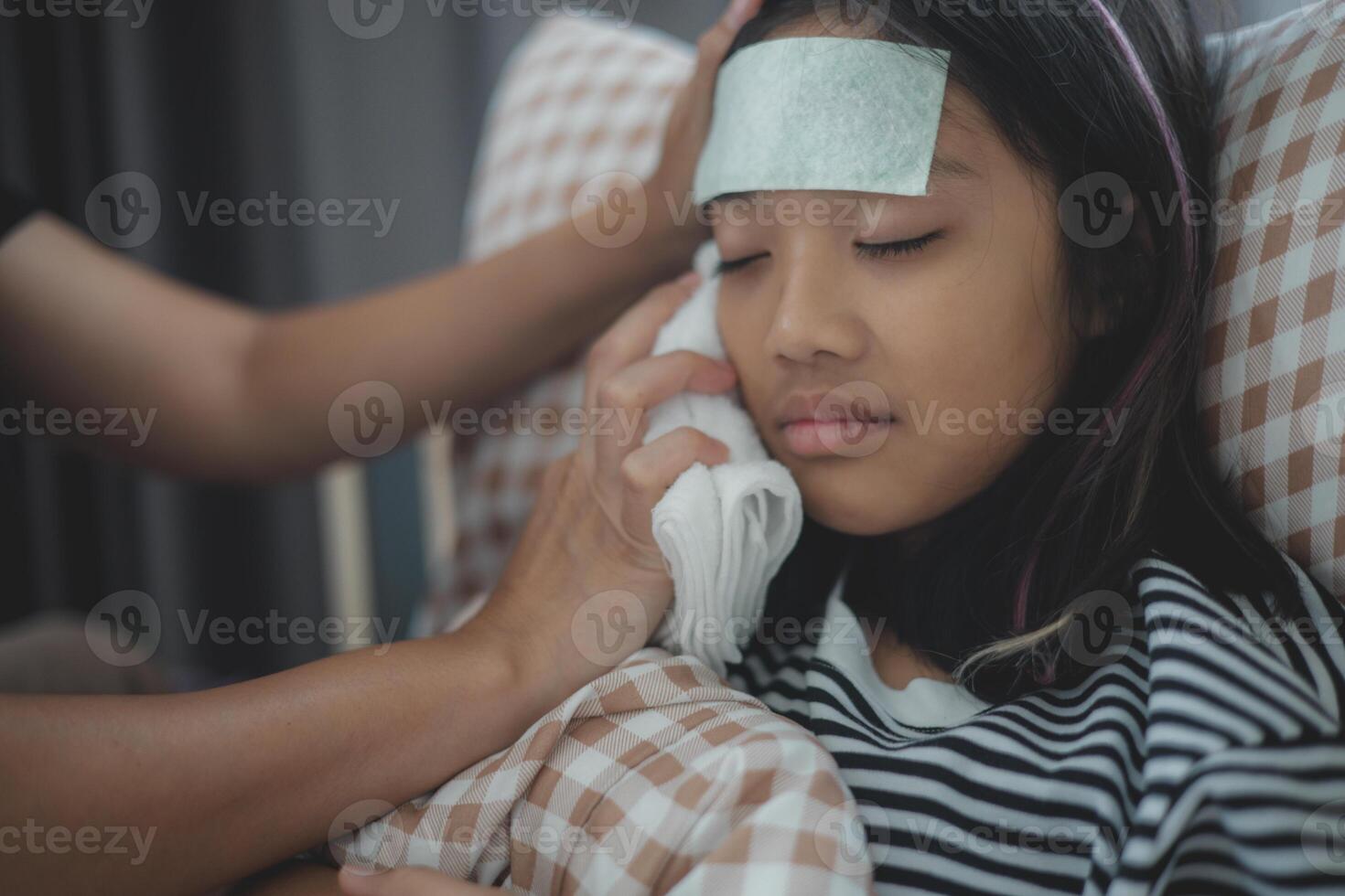A woman is helping a young girl with a bandaged forehead photo