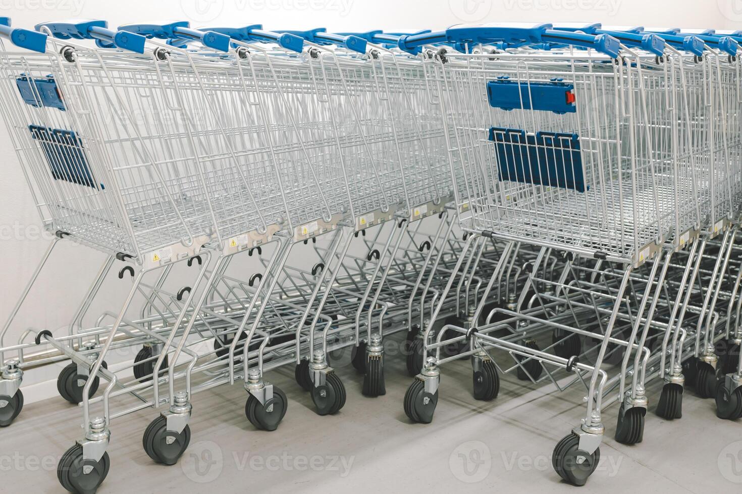 Rows of shopping carts on car park near entrance. row of empty shopping carts in the supermarket. photo
