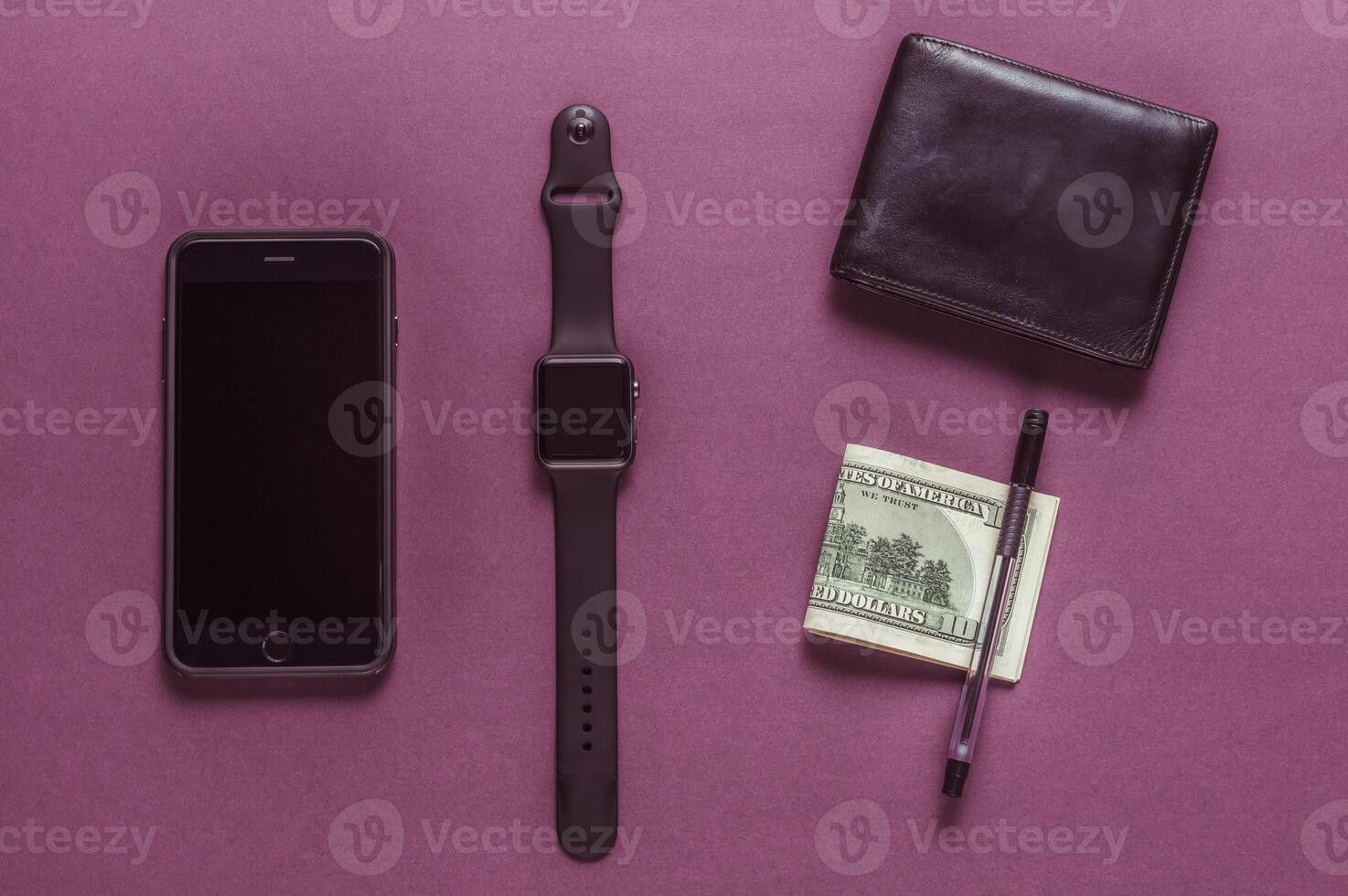 Business concept. Top view of dollars, watch, smartphone on color background photo
