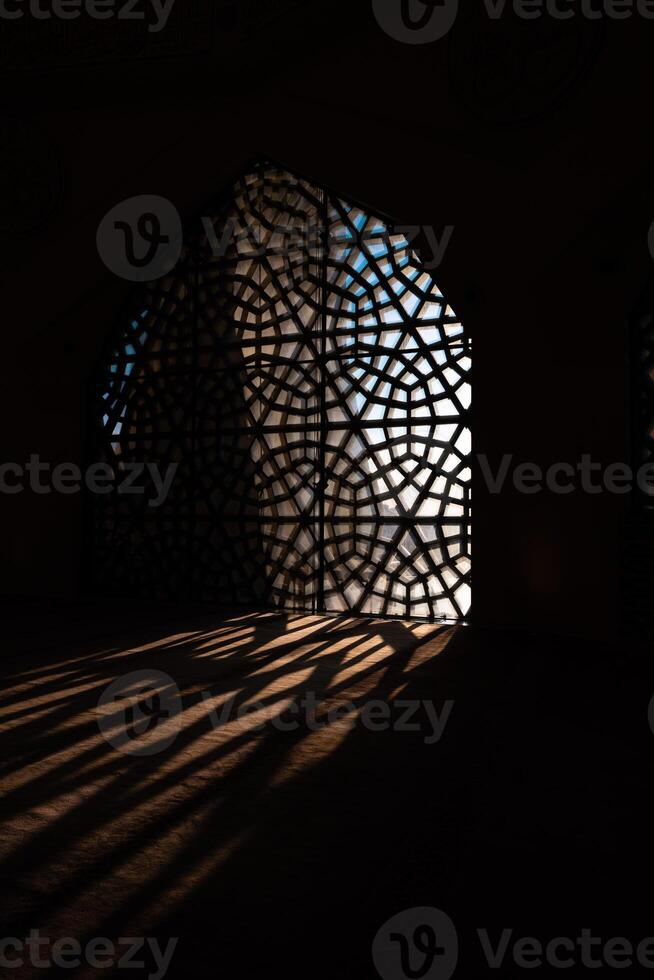 Islamic concept vertical photo. Islamic patterns on the window and shadows photo