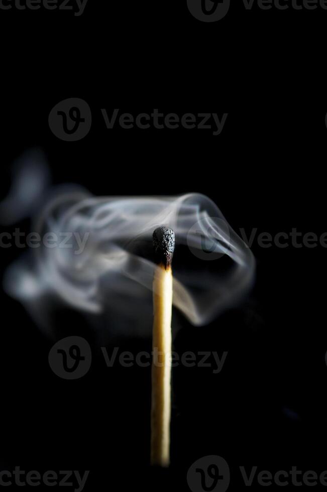 Wooden match burning on a black background photo