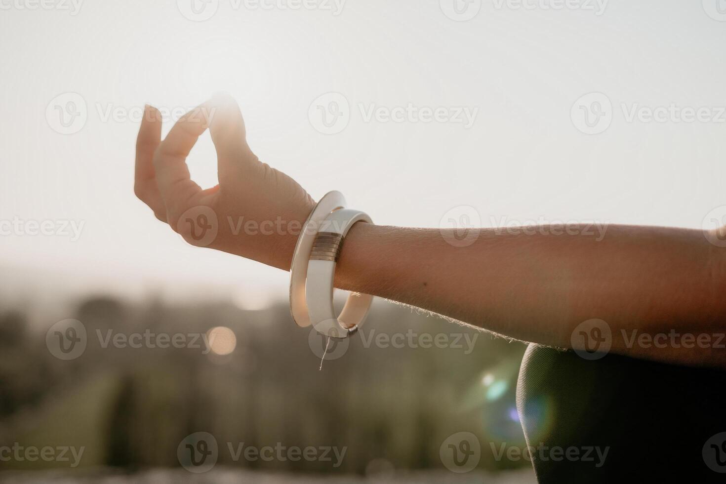 Fitness woman. Well looking middle aged woman with long hair, fitness instructor in leggings and tops doing stretching and pilates on the rock near forest. Female fitness yoga routine concept. photo