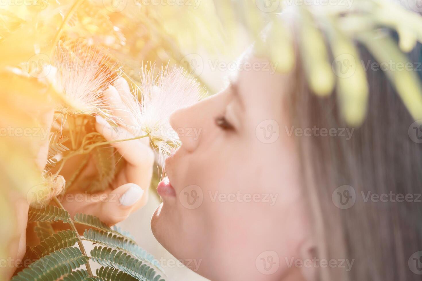 Beauty portrait of happy woman closeup. Young girl smelling Chinese acacia pink blossoming flowers. Portrait of young woman in blooming spring, summer garden. Romantic vibe. Female and nature photo