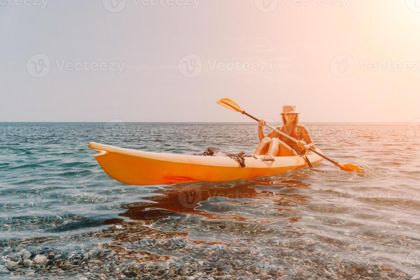 Woman sea kayak. Happy smiling woman paddling in kayak on ocean. Calm sea water and horizon in background. Active lifestyle at sea. Summer vacation. photo