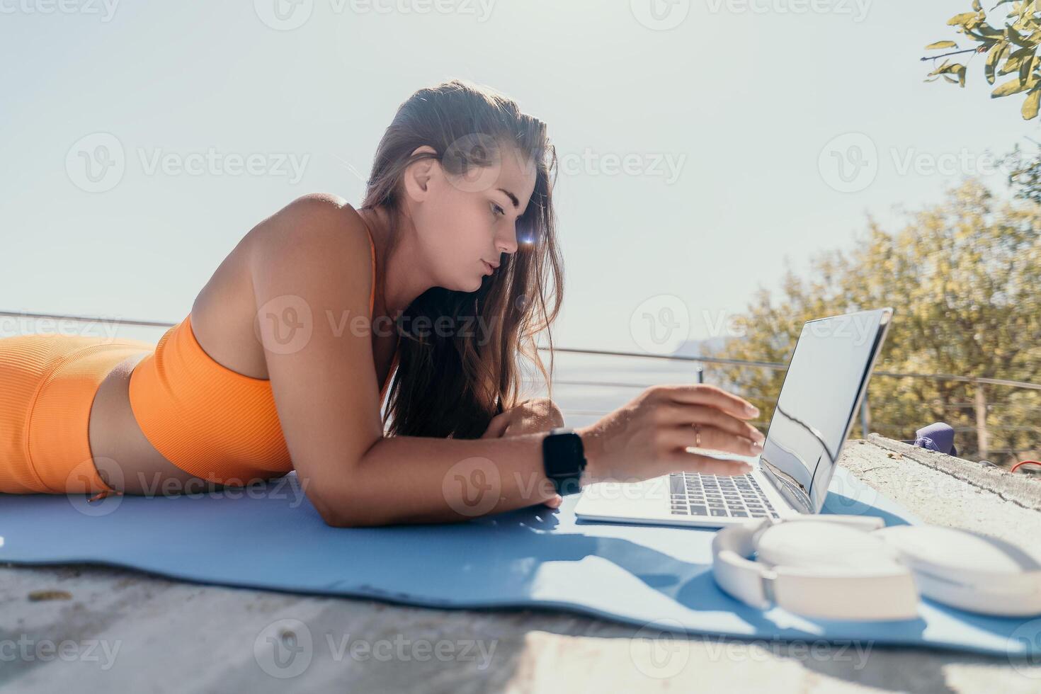 Woman laptop sea. Working remotely on seashore. Happy successful woman female freelancer working on laptop by the sea at sunset, makes a business transaction online. Freelance, remote work on vacation photo