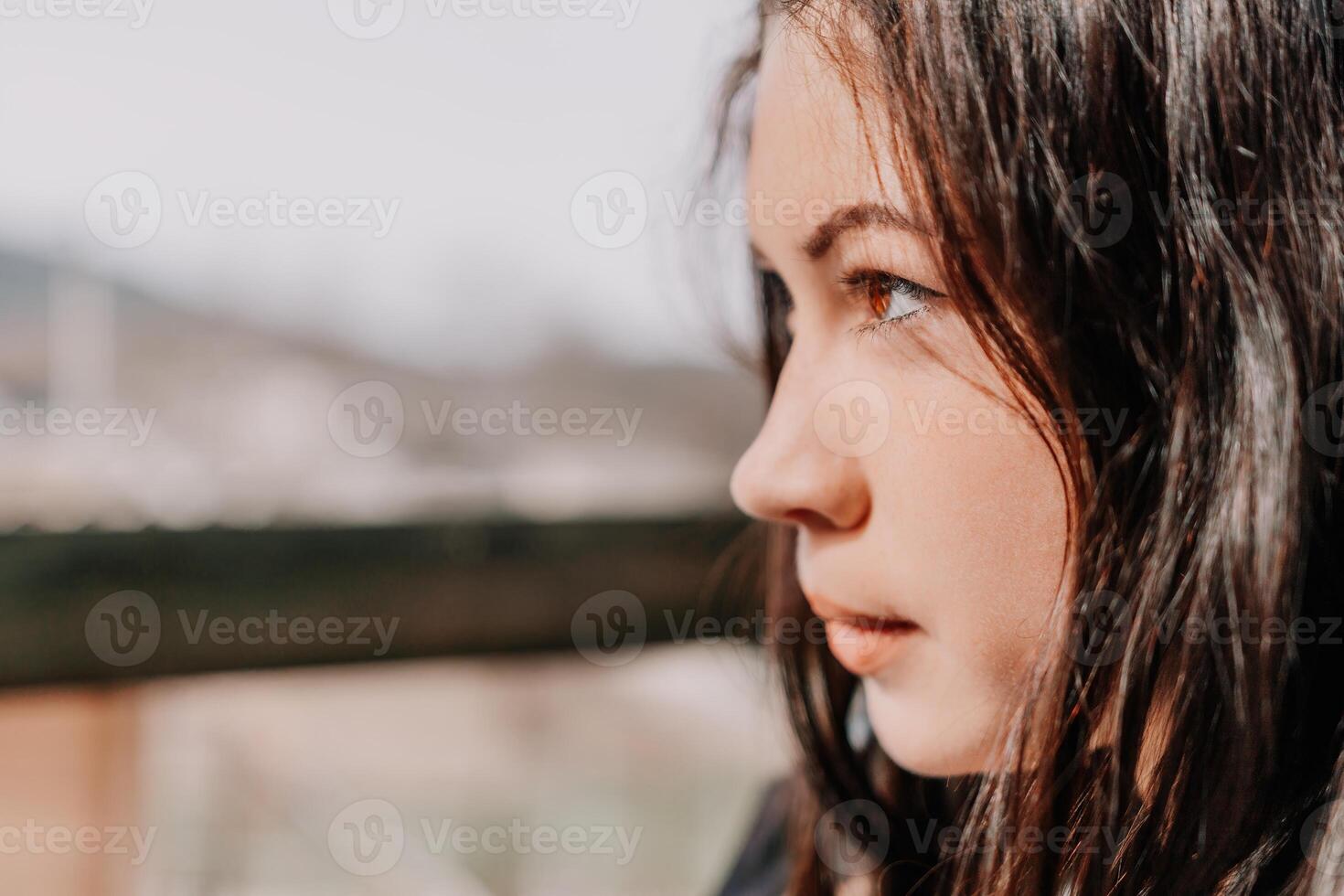 Happy young smiling woman with freckles outdoors portrait. Soft sunny colors. Outdoor close-up portrait of a young brunette woman and looking to the camera, posing against autumn nature background photo
