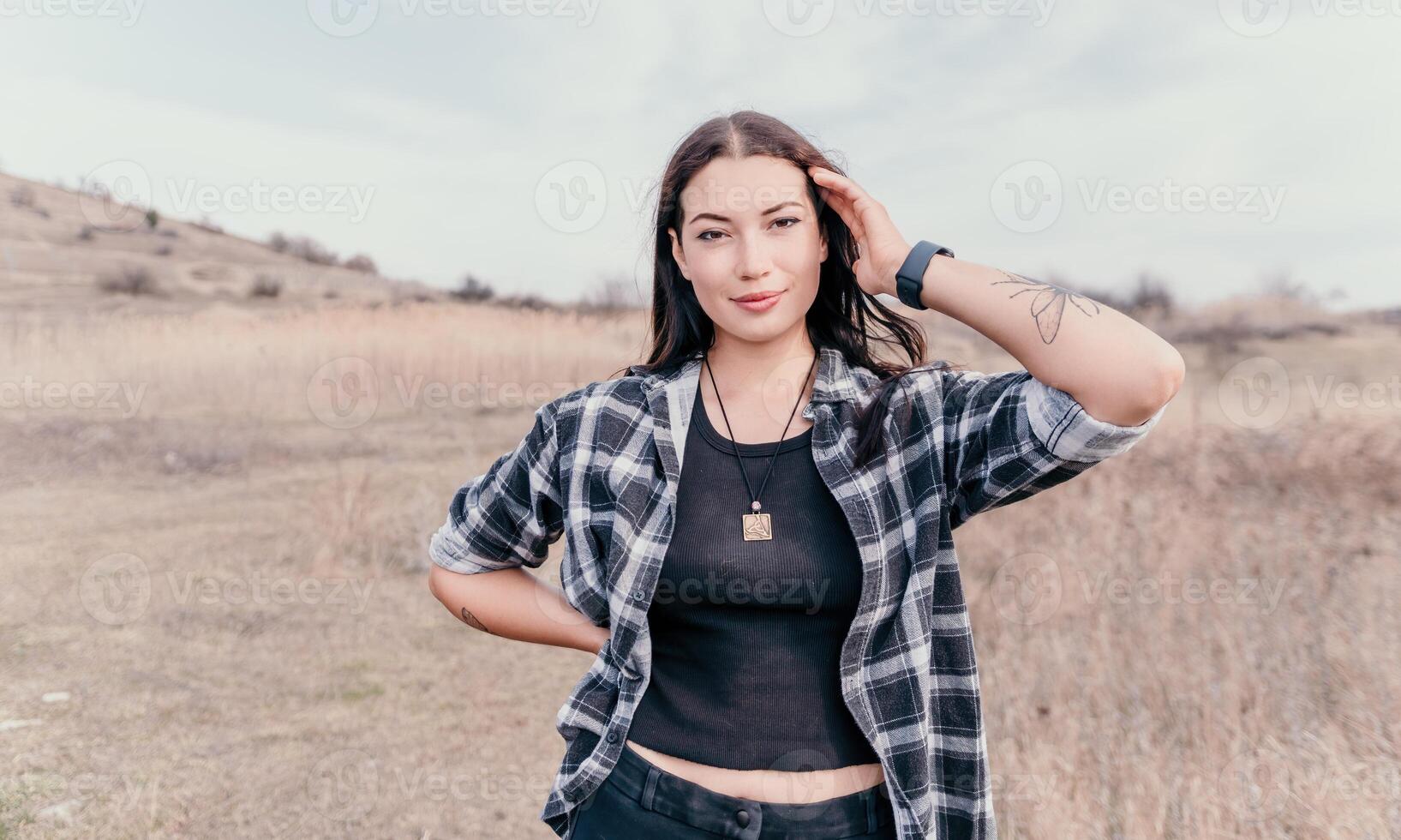 Happy young smiling woman with freckles outdoors portrait. Soft sunny colors. Outdoor close-up portrait of a young brunette woman and looking to the camera, posing against autumn nature background photo