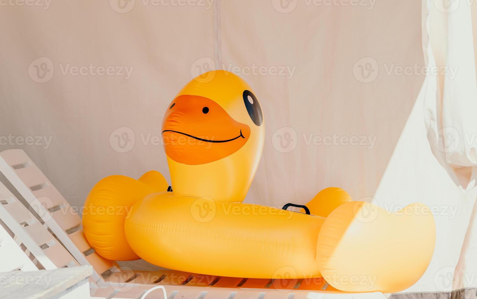 Inflatable duckling, summer - Bright yellow floatation device enhances swimming experience and safety ensured for young swimmers on warm summer days. photo