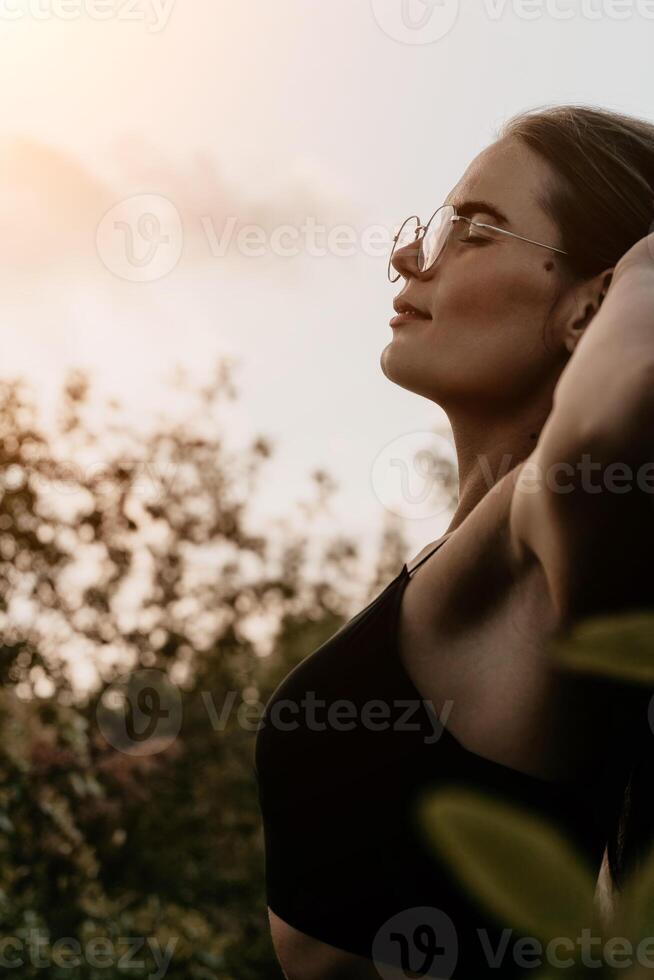 Woman summer travel. Happy tourist enjoy taking selfie photo outdoors for memories. Woman traveler posing in summer park on sunset, sharing travel adventure journey