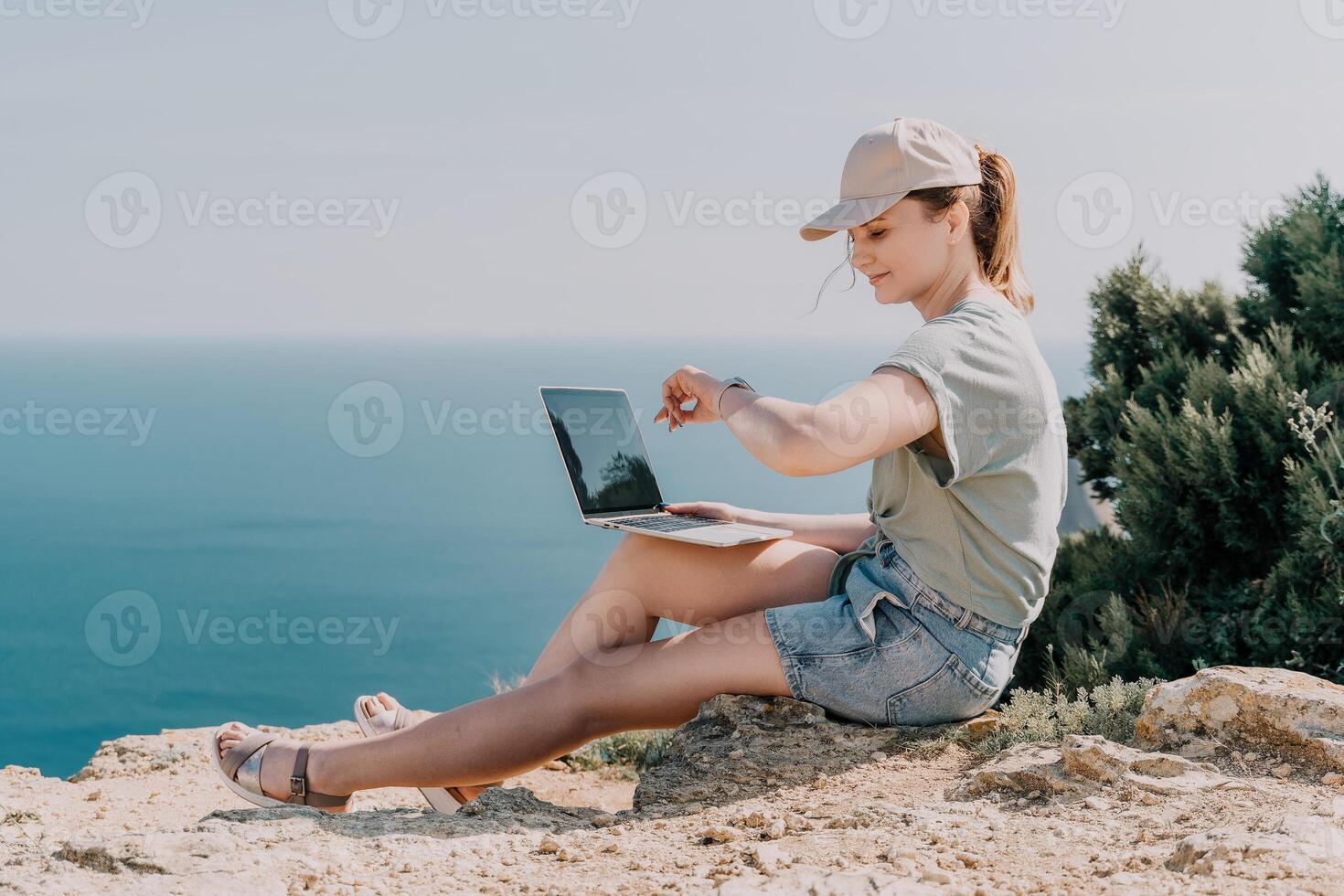 Woman sea laptop. Business woman, freelancer with laptop working over blue sea beach. Happy smiling girl relieves stress from work. Freelance, remote work on vacation, digital nomad, travel concept photo