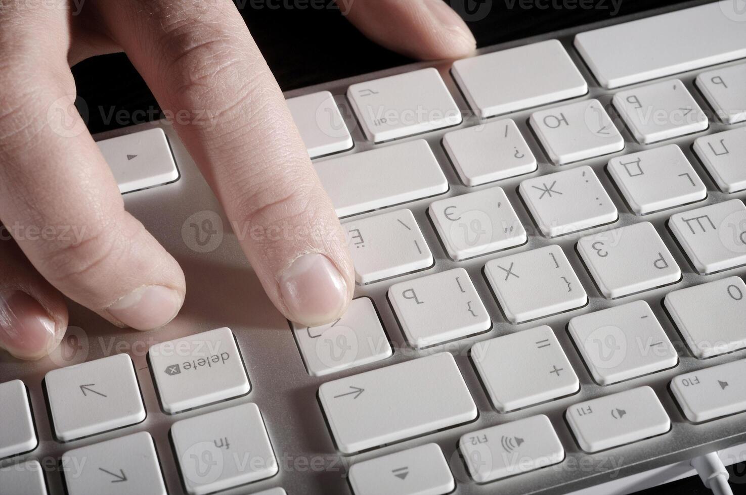 The man's hand works with the keyboard photo