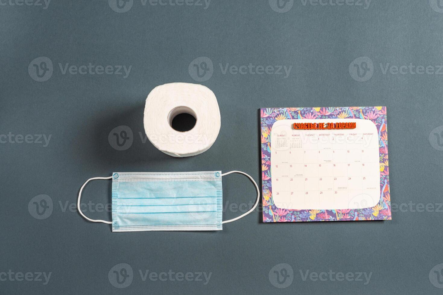 Top view of grey color office table with calendar and surgical face mask. photo