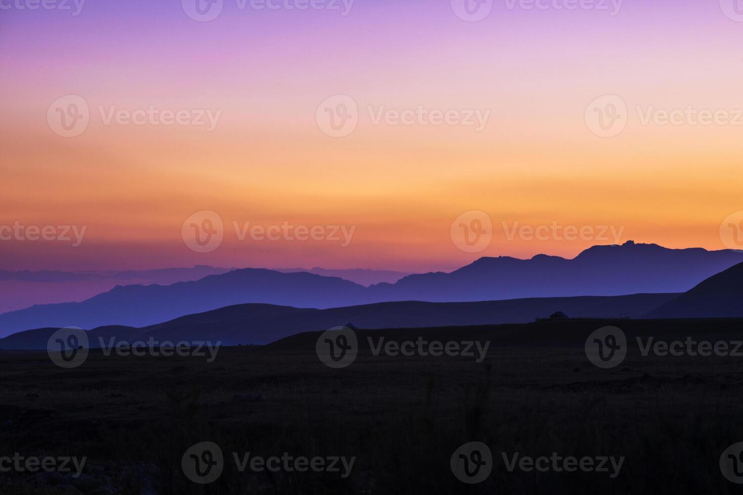 view of a valley in a beautiful early night with fog between hills photo