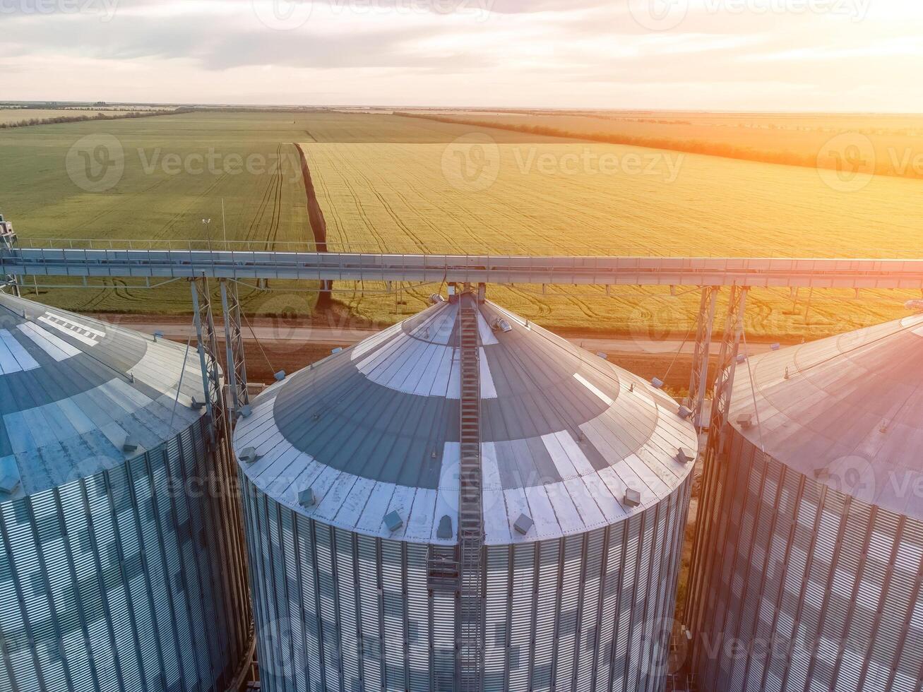 Modern metal silos on agro-processing and manufacturing plant. Aerial view of Granary elevator processing drying cleaning and storage of agricultural products, flour, cereals and grain. Nobody. photo