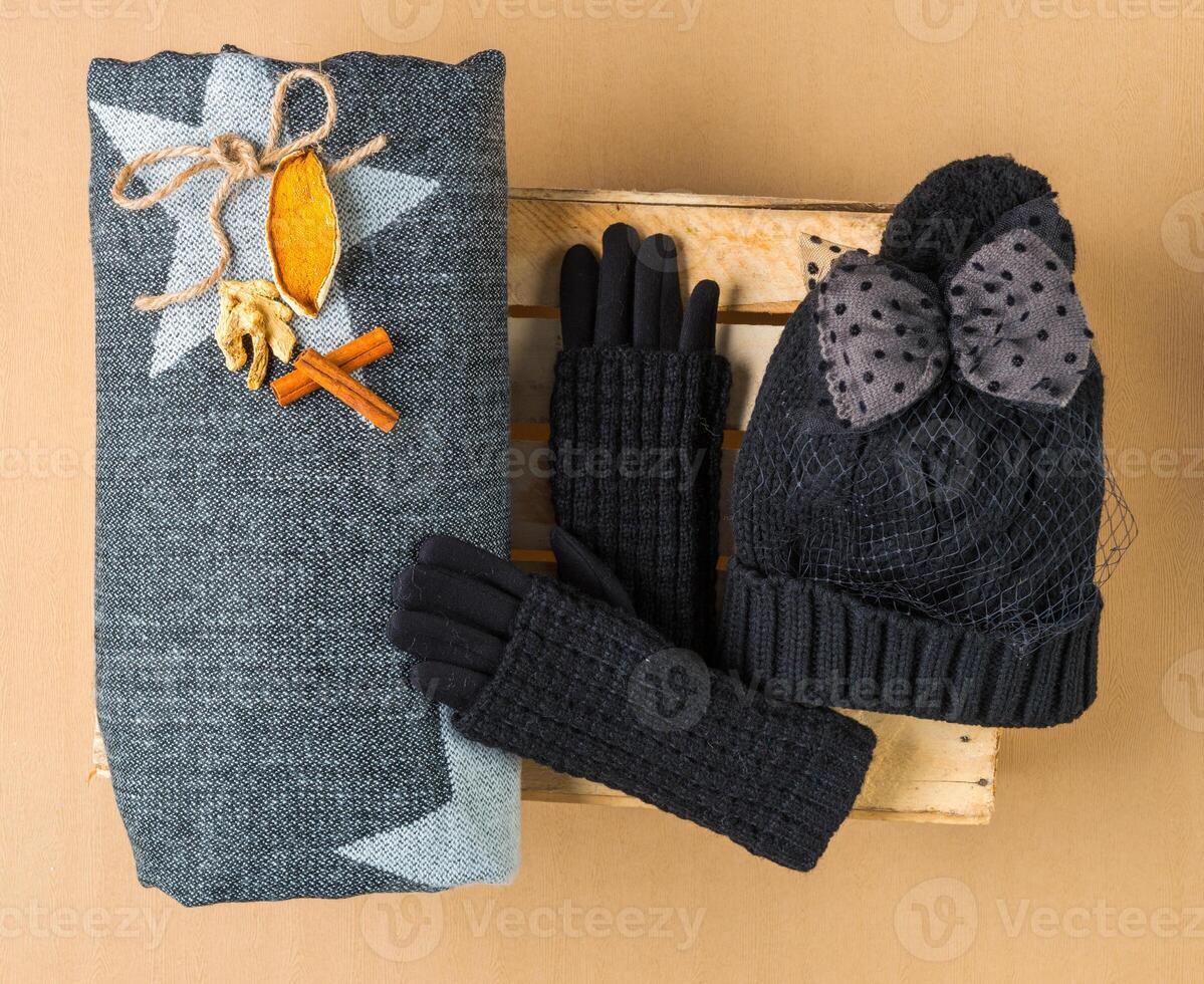 Set of winter cap, scarf and gloves on colored background photo