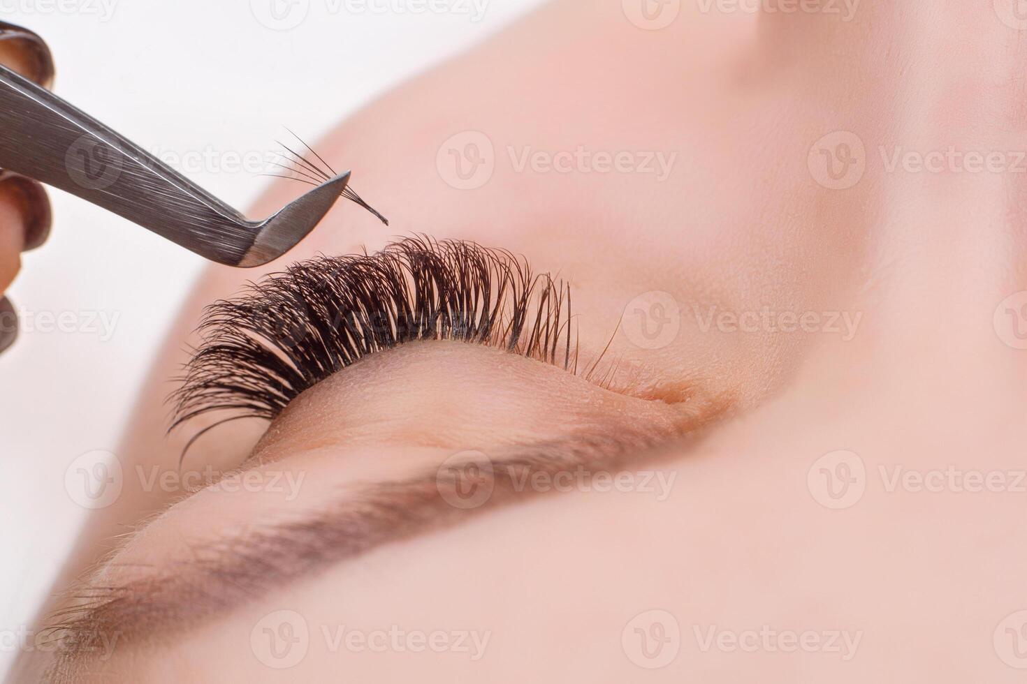 Eyelash Extension Procedure. Woman Eye with Long Eyelashes. Lashes, close up, macro, selective focus. photo