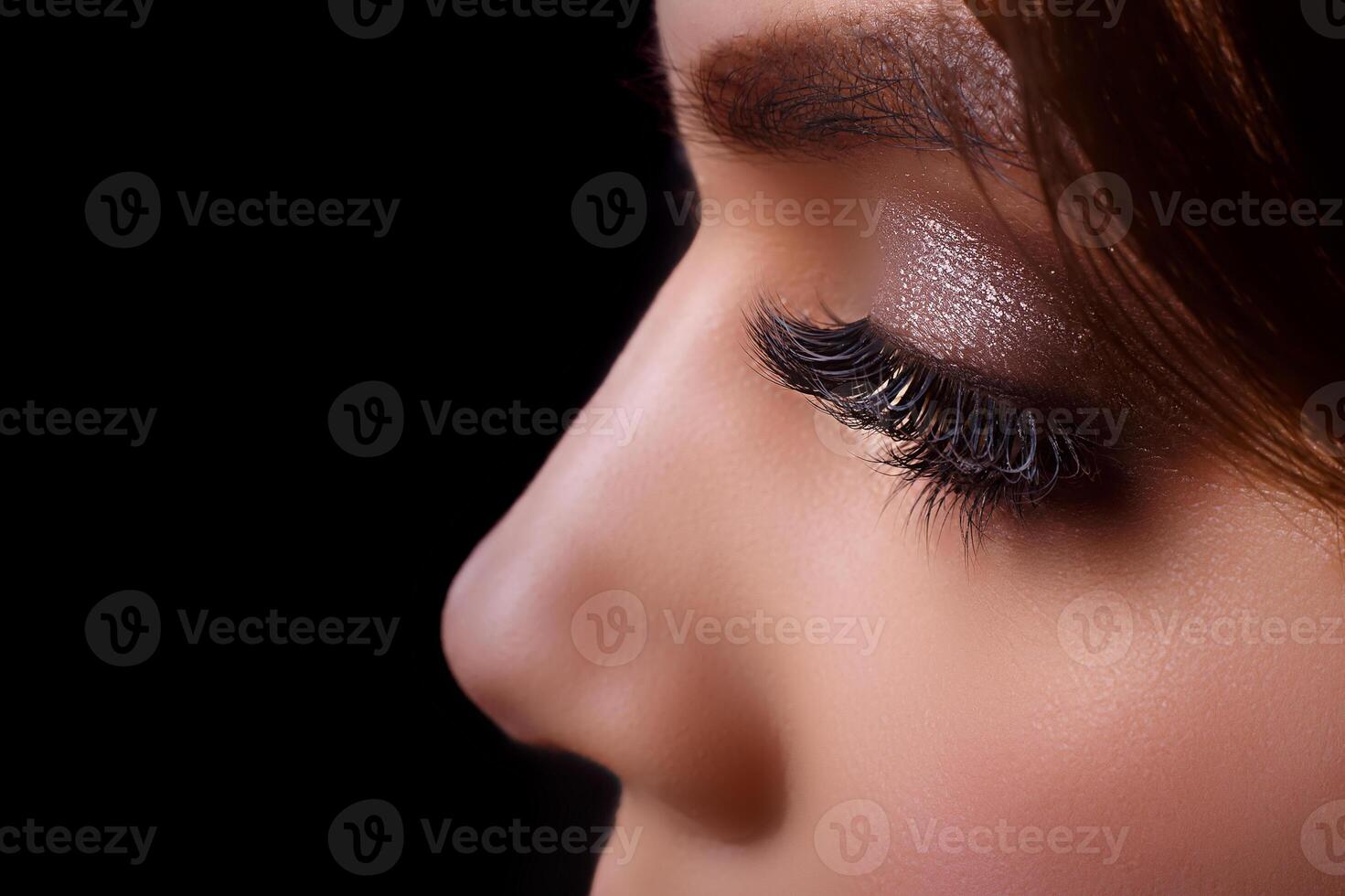 Eyelash Extension Procedure. Woman Eye with Long Eyelashes after Extension Procedure. White eyelashes. Dark background. Makeup. Close up, selective focus. photo