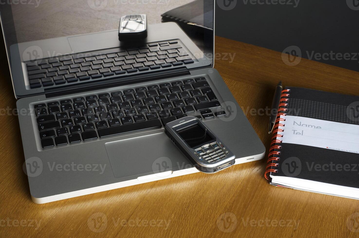 Phone, laptop and empty notebook on the desk photo