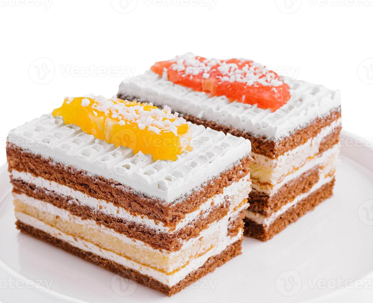 two slices of multilayer cocoa sponge cake with coconut flakes photo