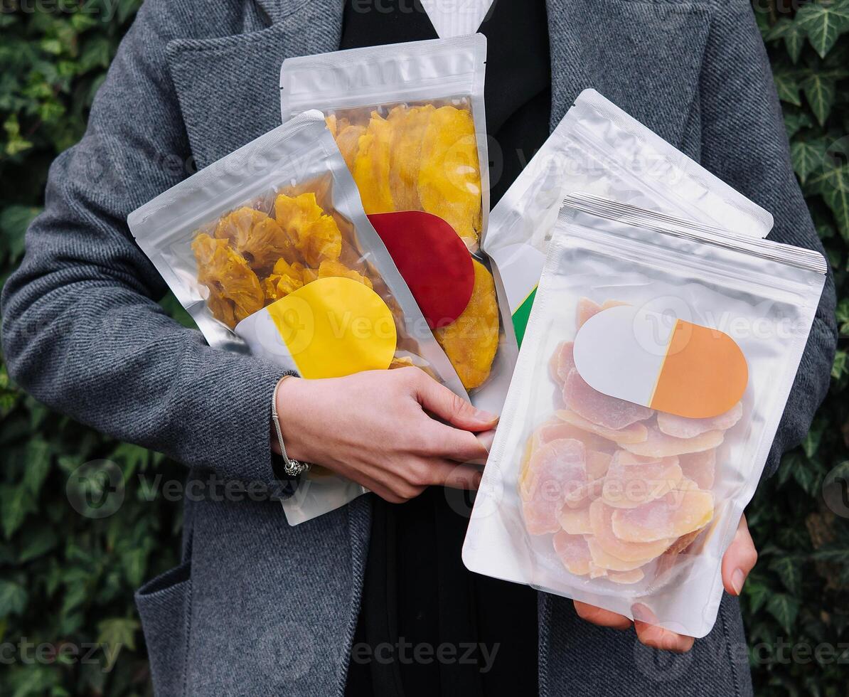 dried pineapple, mango in a package in hands girl photo