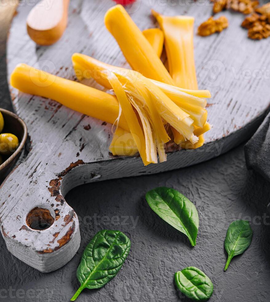 Smoked braided cheese on wooden board photo