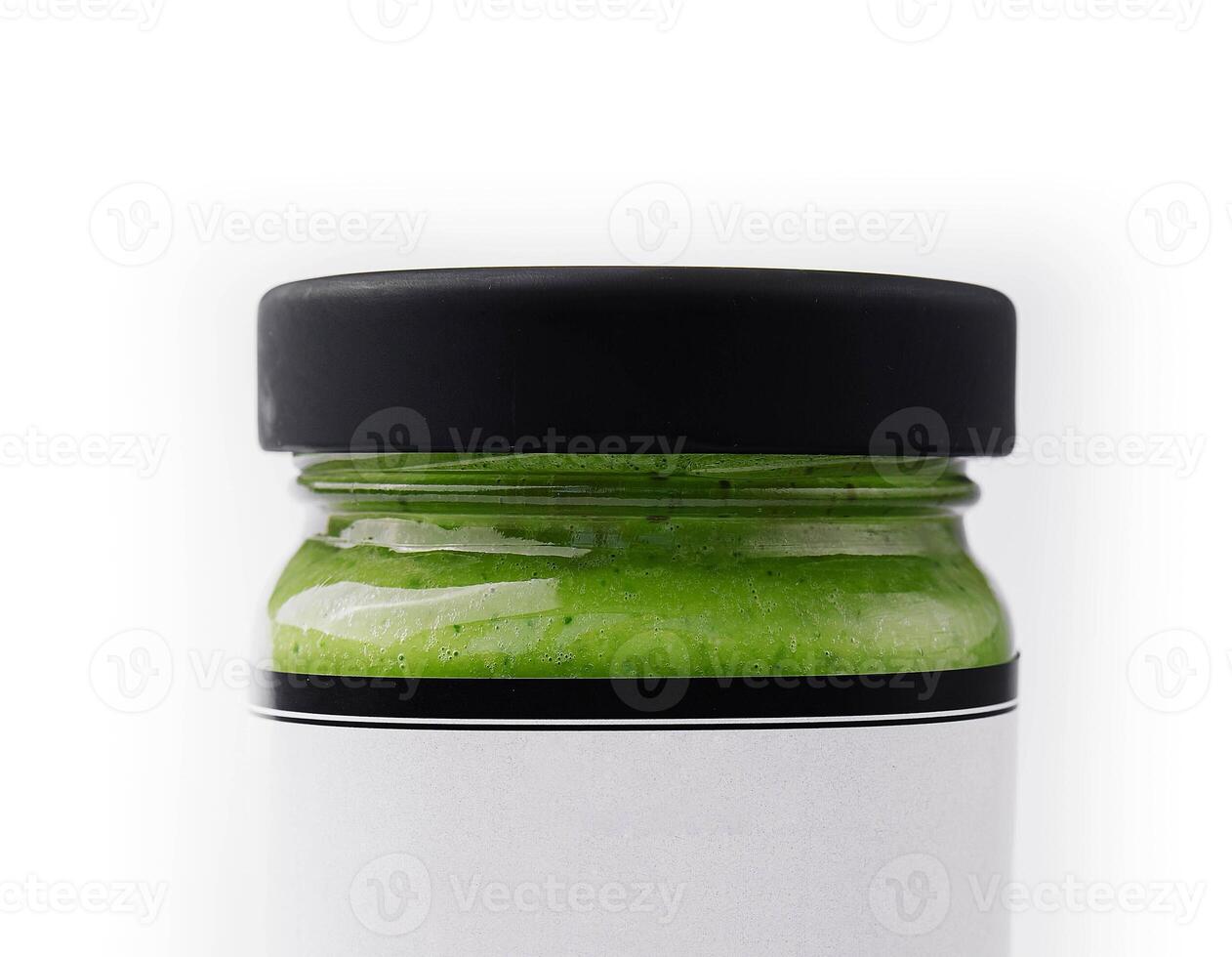 Pesto sauce in a glass jar isolated photo