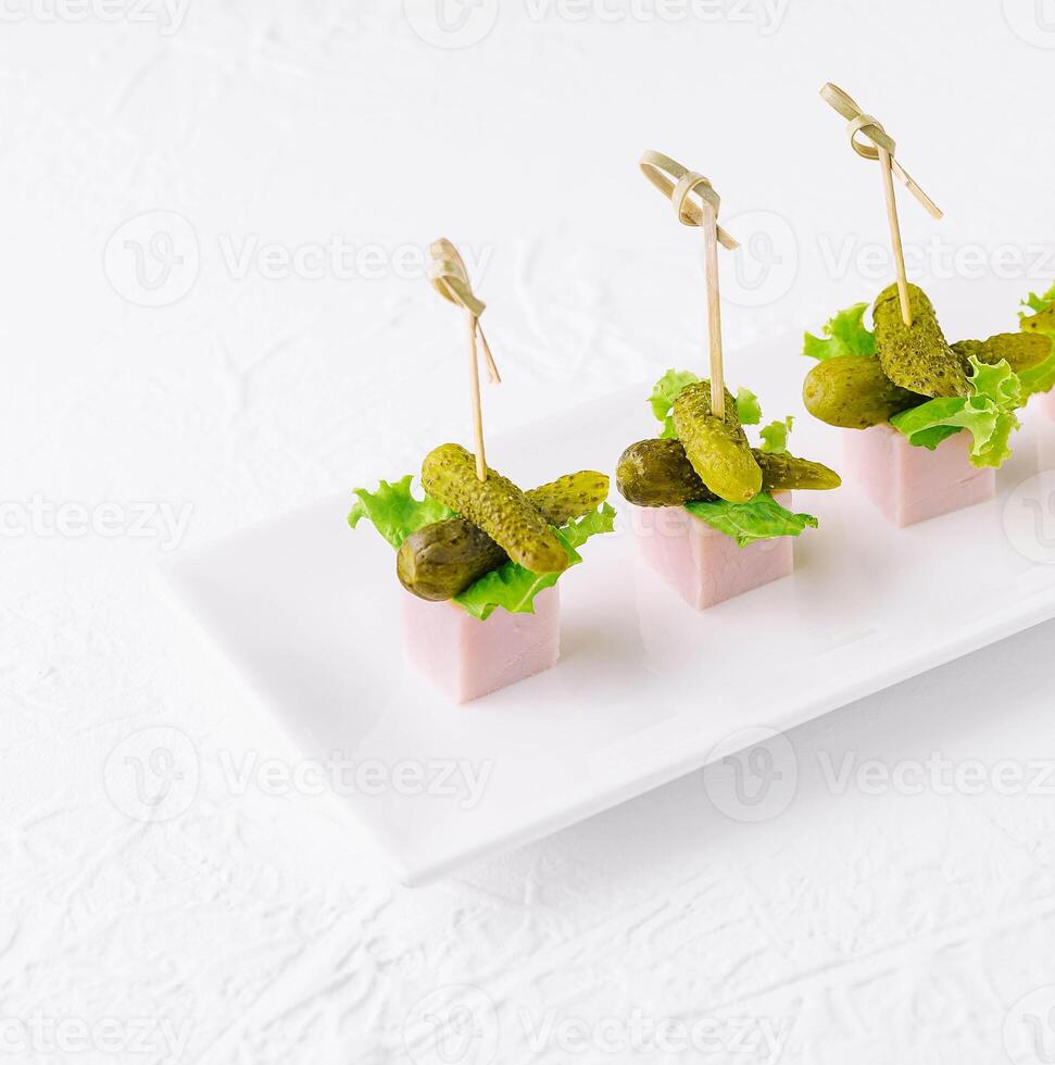 pieces of ham with small pickled cucumbers photo