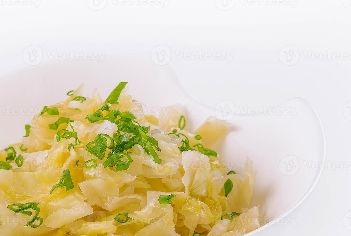 Bowl of tasty fermented cabbage on white photo